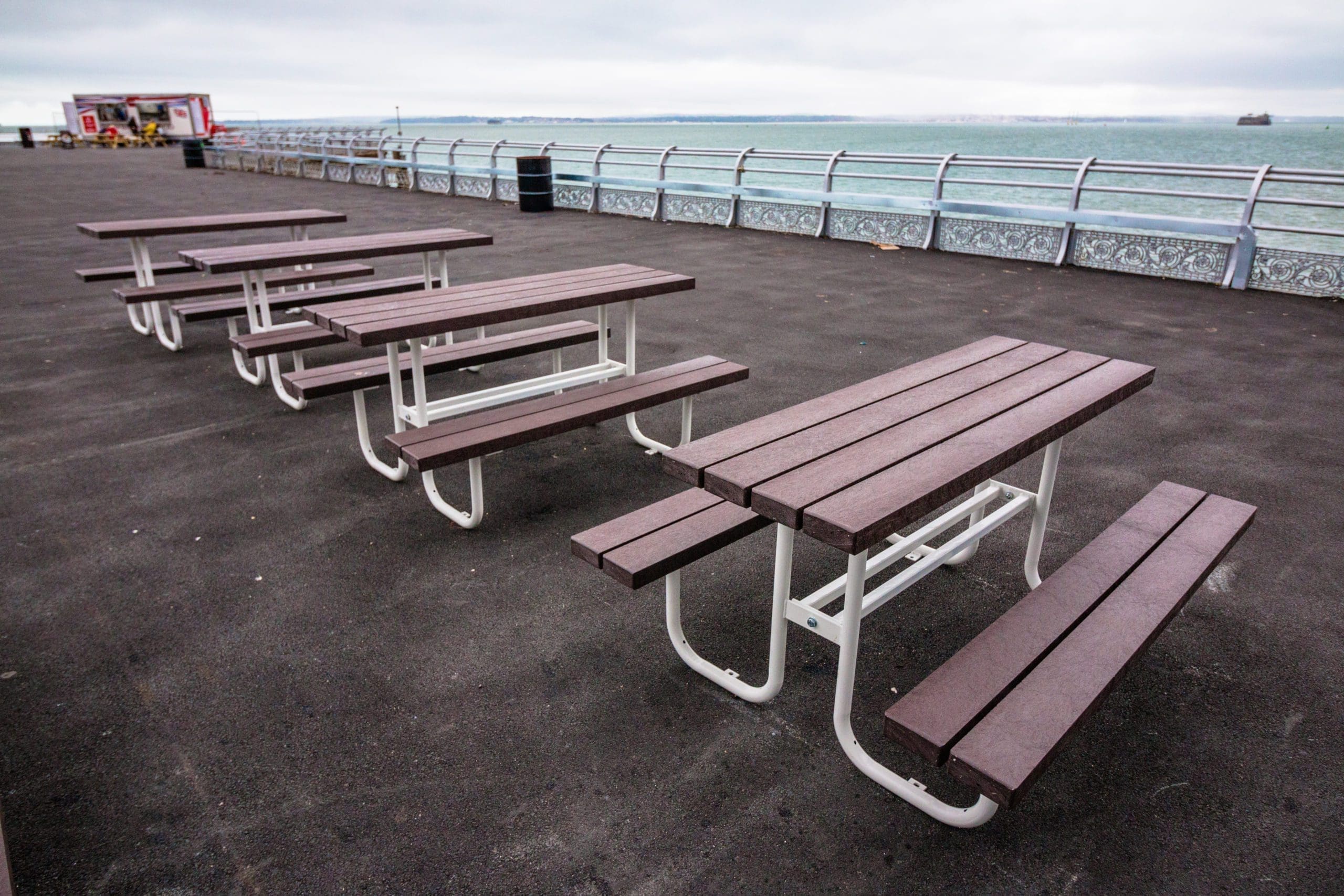 Row of outdoor wooden picnic table with metal legs