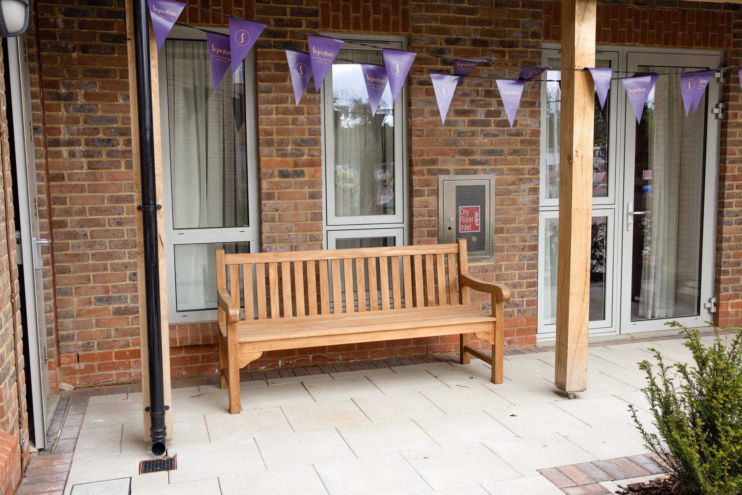 Traditional wooden park bench infront of care home