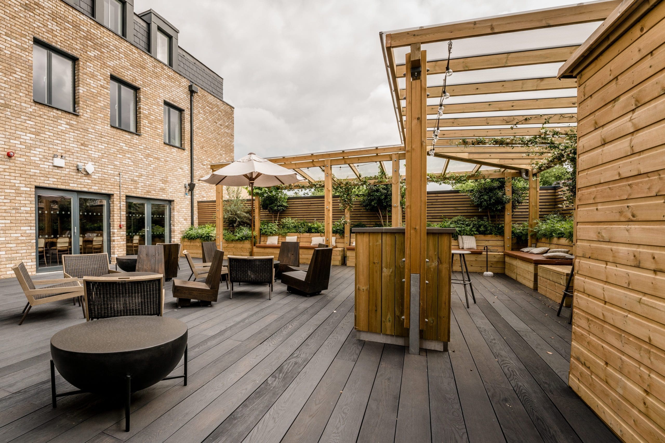 bespoke wooden pergolas with built in benches attached to raised planters