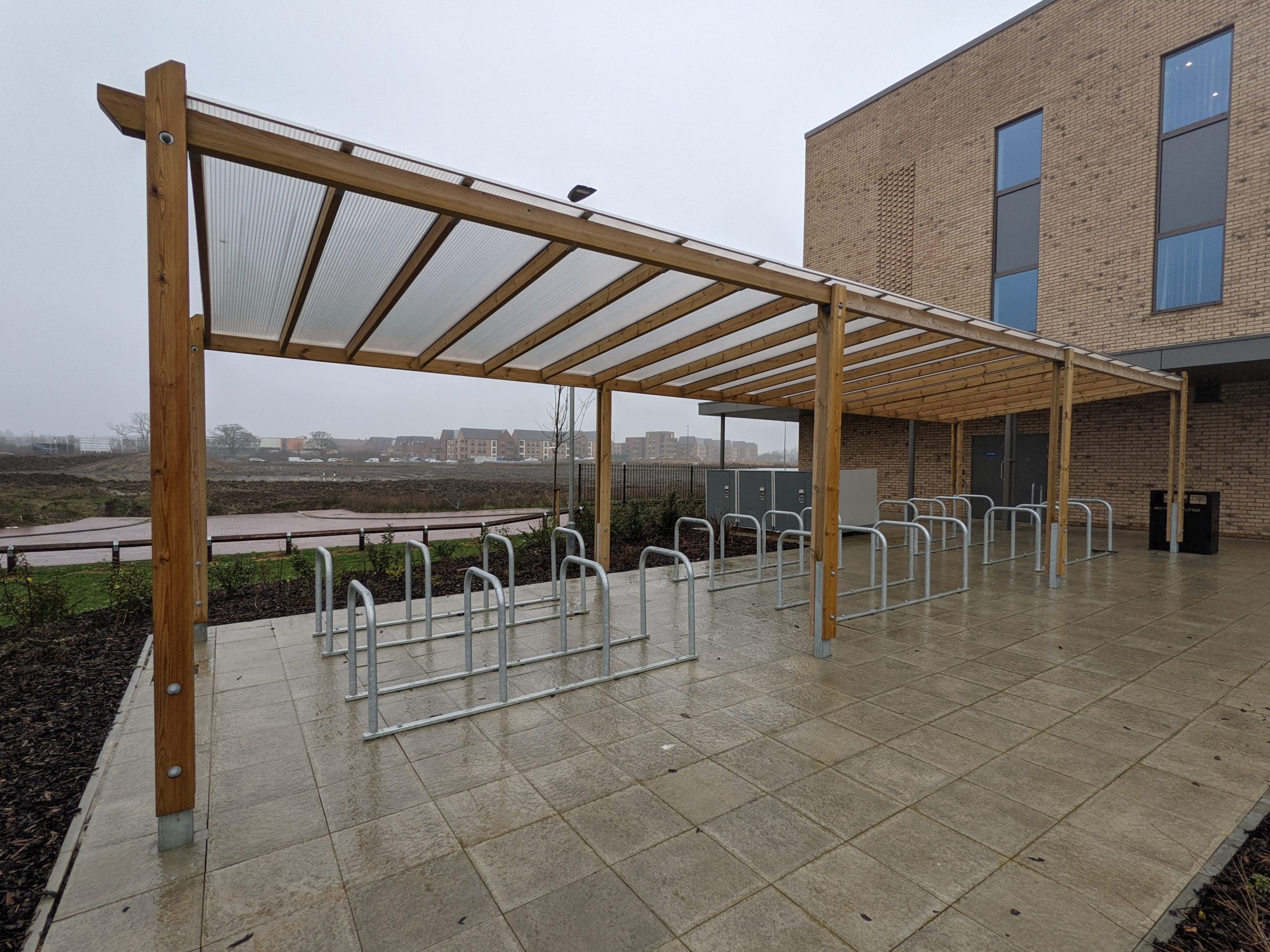 Outdoor pergola canopy covering rows of metal bicycle security hoops