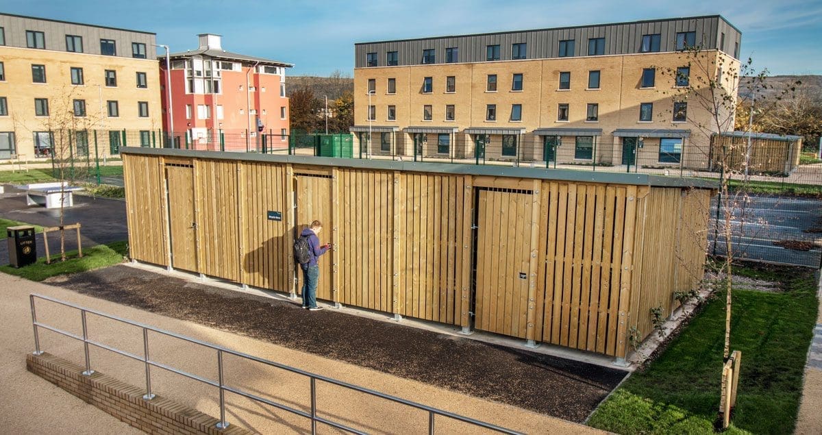 Large outdoor wooden bicycle storage unit infront of university building