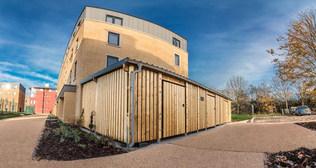Large outdoor wooden bicycle storage unit infront of university building
