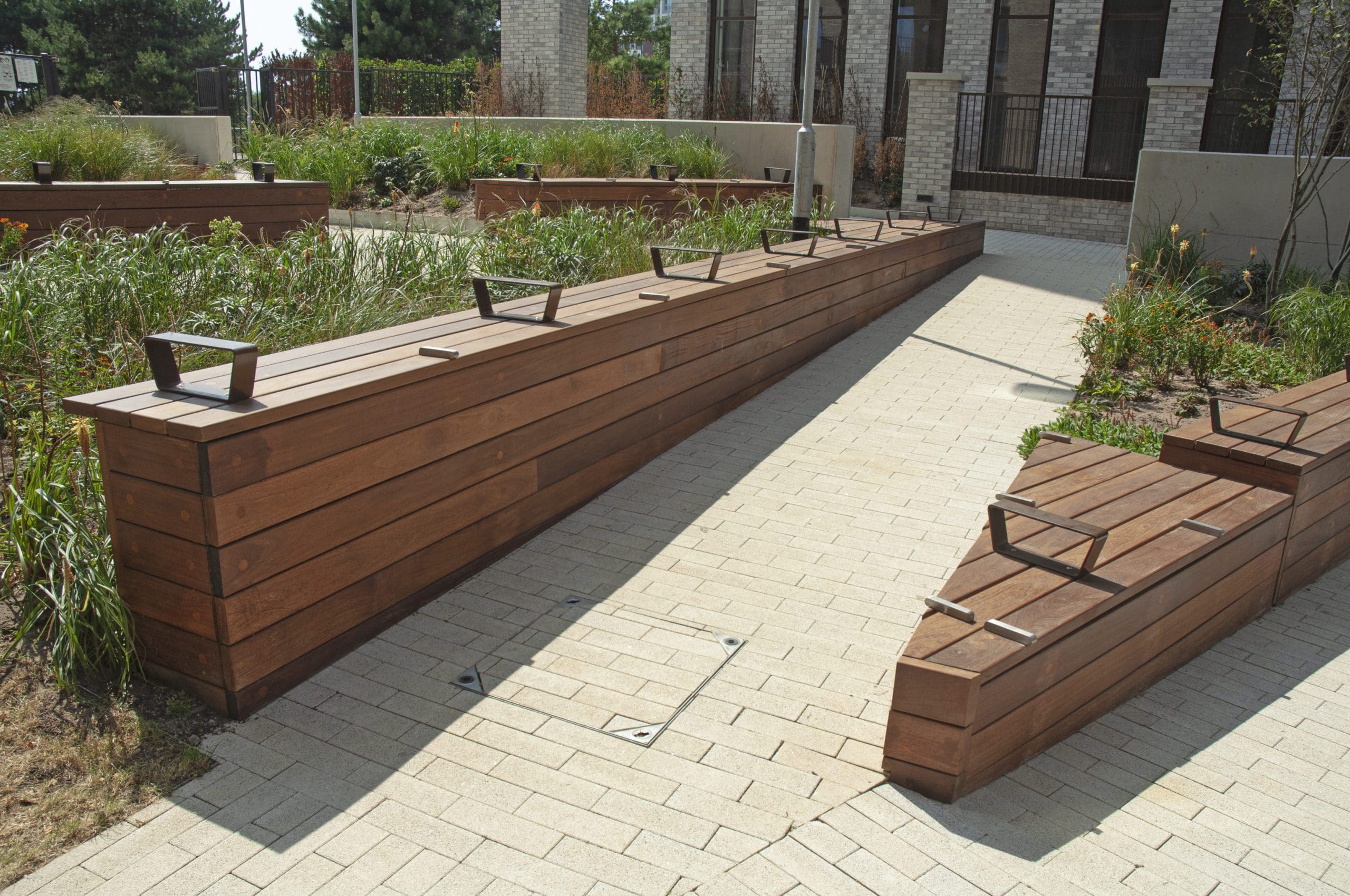 Angled zig zag wooden timber decking creating long bench seating areas and forming up hill pathway