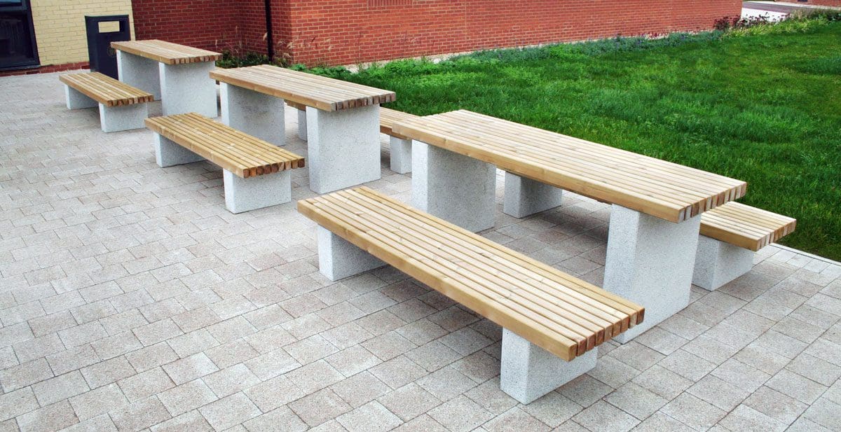 Outdoor wooden picnic table and matching benches with concrete plinth legs