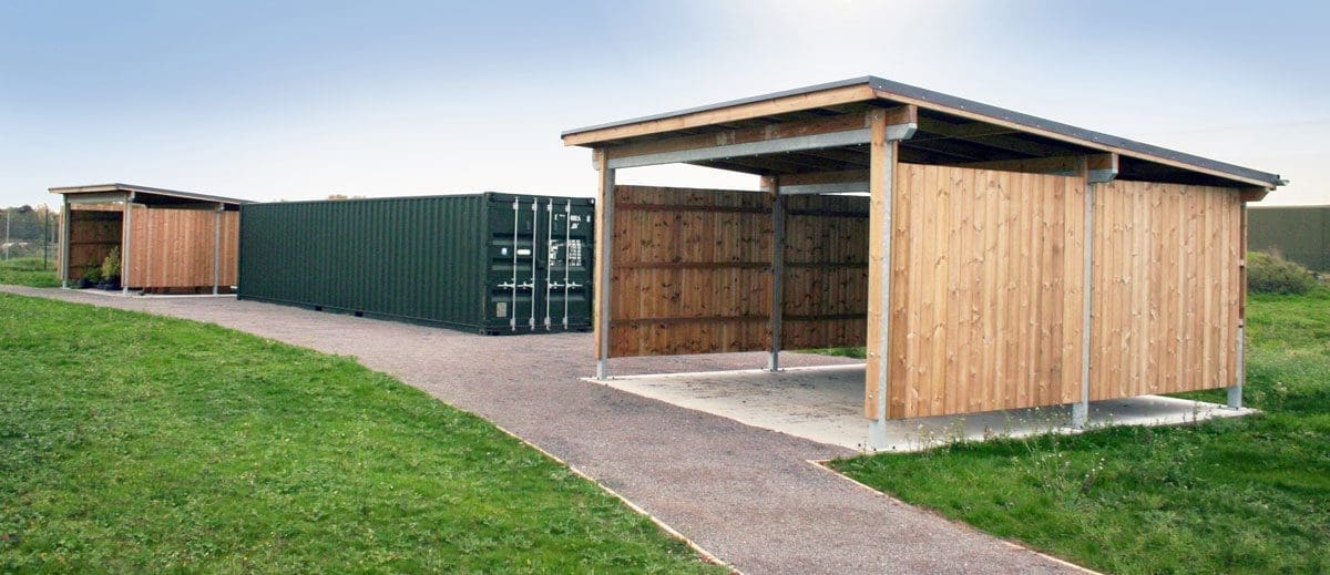 Outdoor wooden shelter structures with iso container in between them