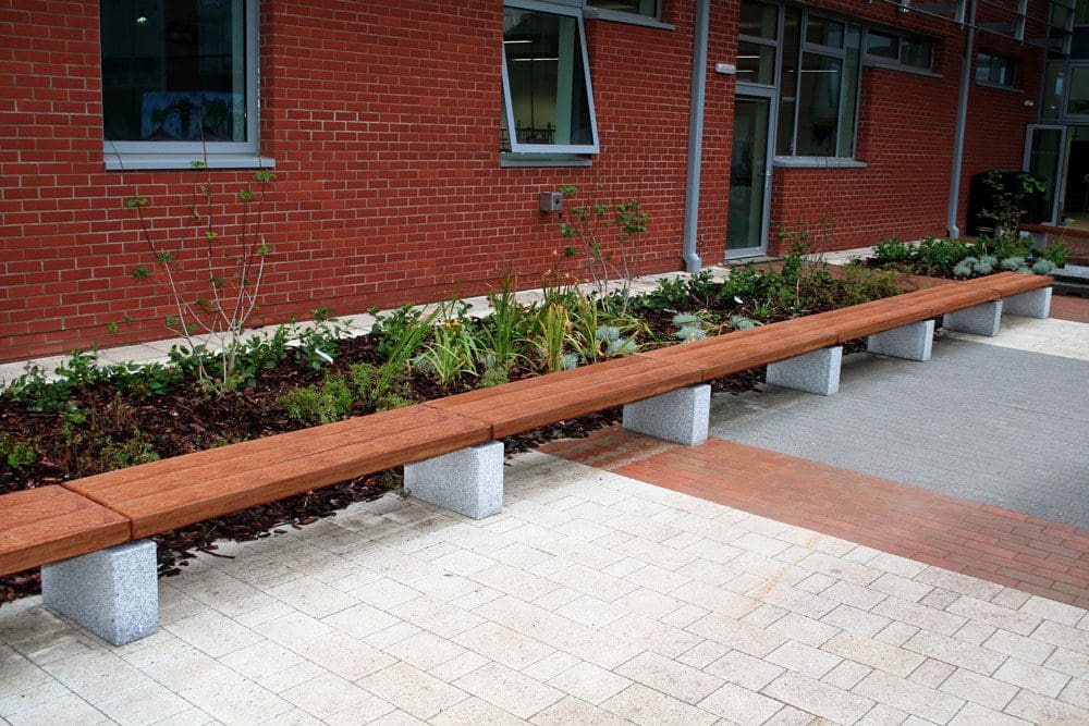 long row of wooden benches with concrete plinth legs