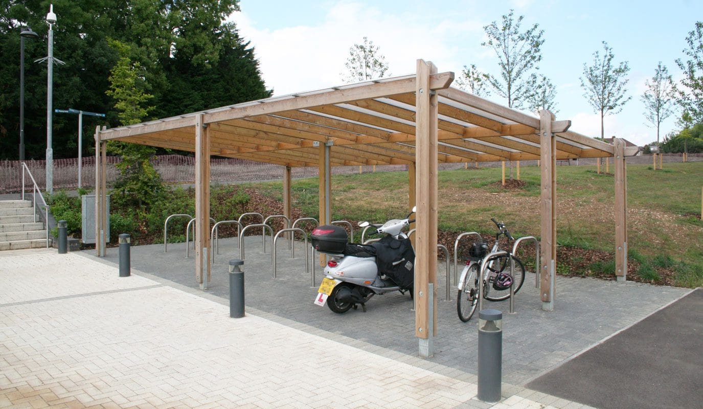 Outdoor wooden pergola with rows of metal bike hoops under cover