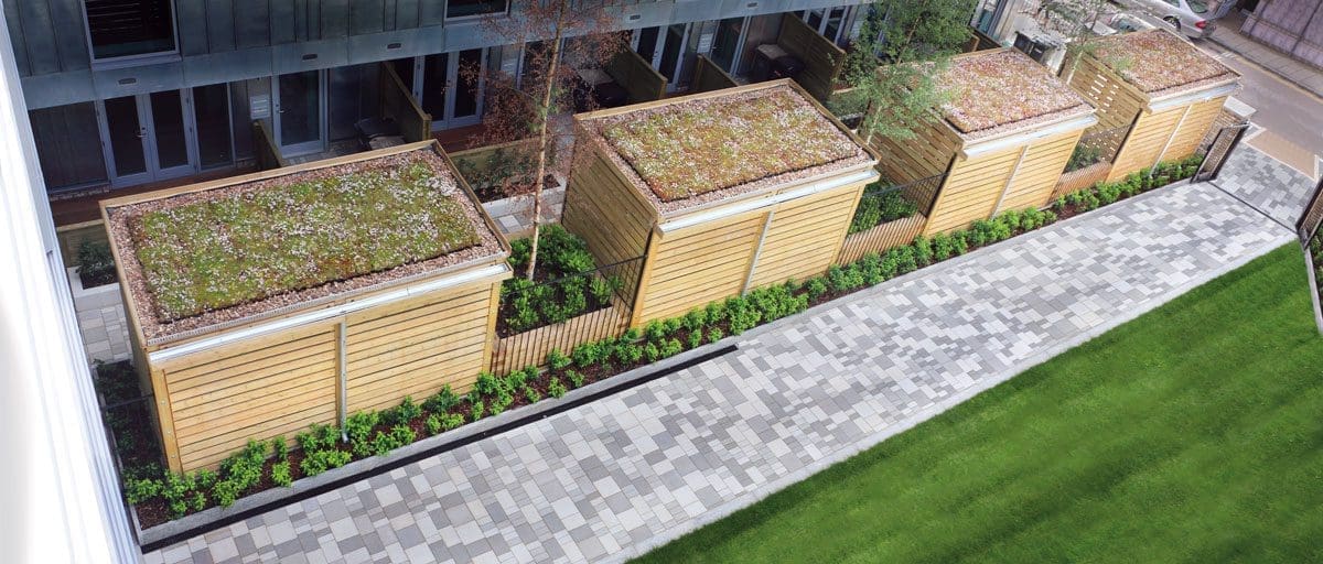 Birdseye view of row of wooden bicycle stores with living roofs separated with raised wooden planters