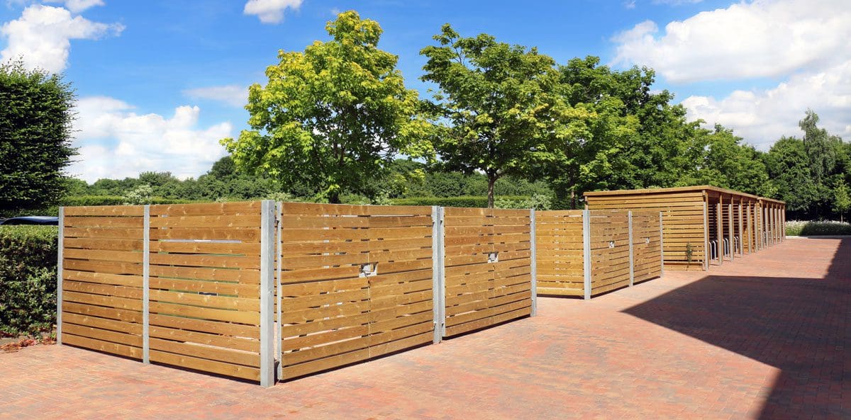 Row of 4 outdoor roofless wooden secure bin stores next to bike storage pergola