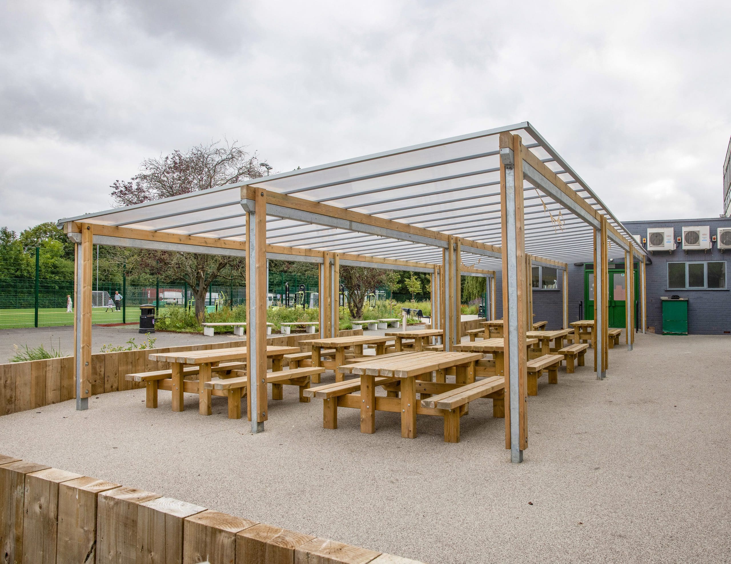 outdoor wooden picnic table and benches under wooden pergola