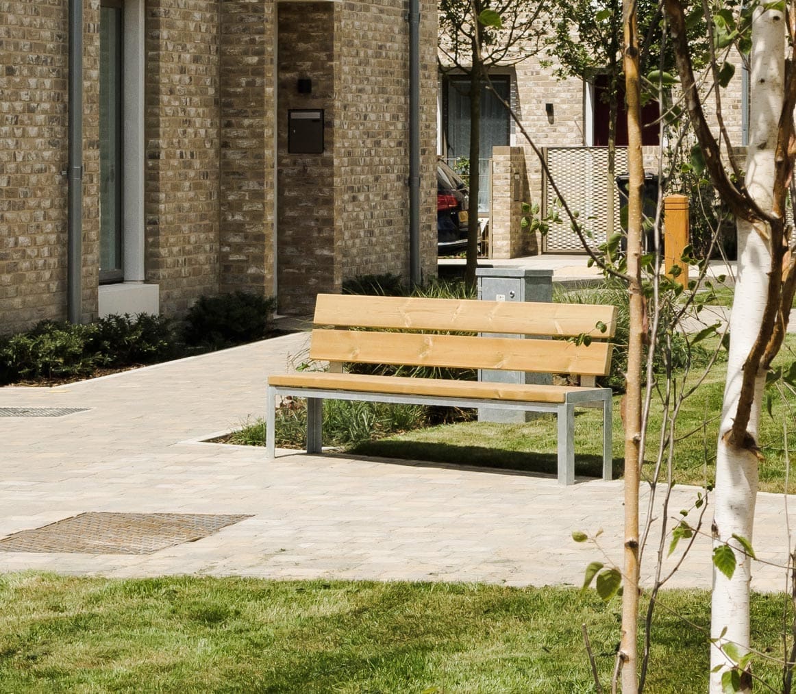 Outdoor communal garden area with wooden park benches with metal legs