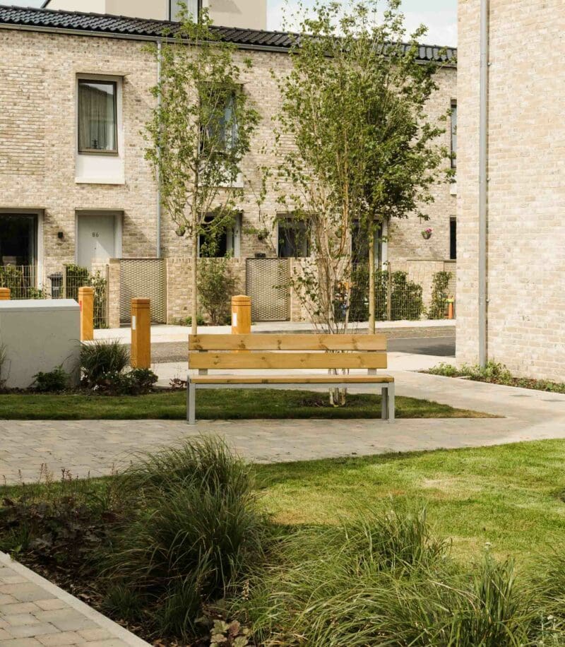 Outdoor communal garden area with wooden park benches with metal legs