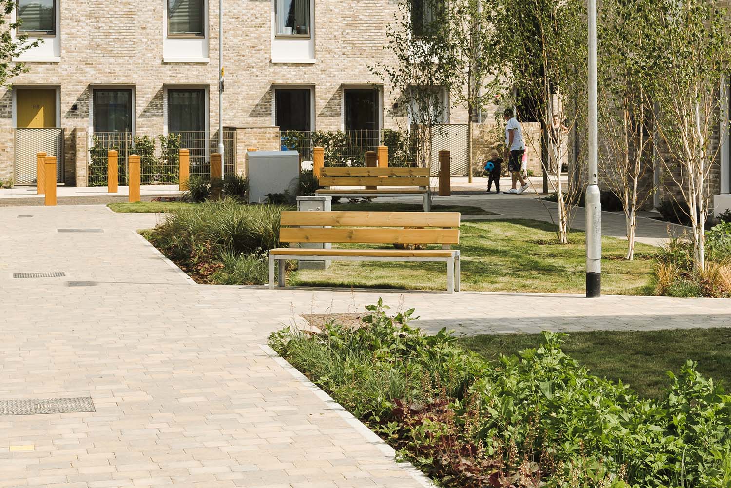 Outdoor communal garden area with wooden park benches with metal legs