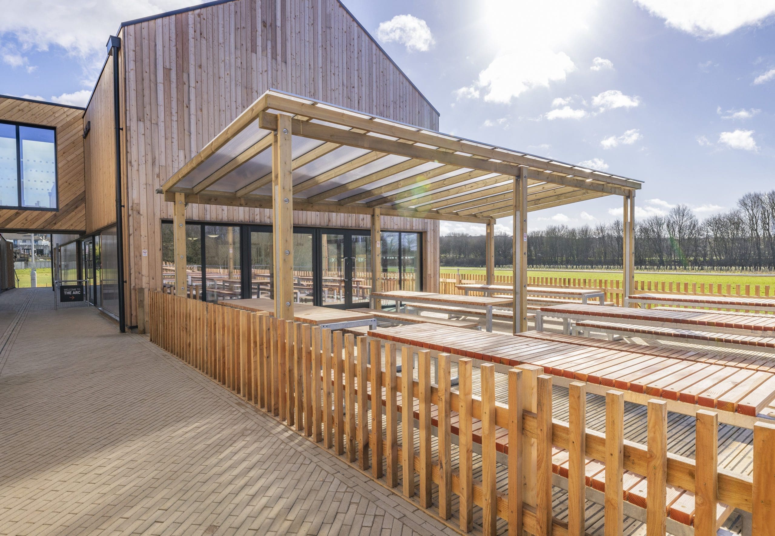 exterior-wooden-seating-area-tables-and-benches-with-wooden-pergola
