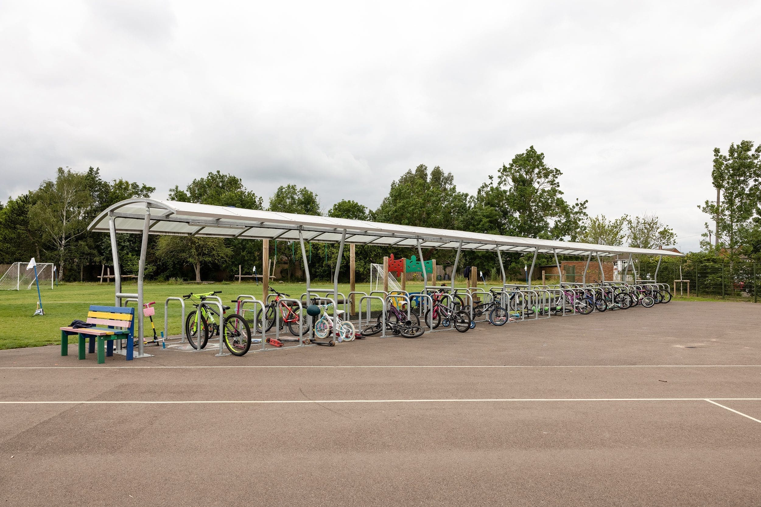 Outdoor large metal bicycle storage with canopy filled with childrens bikes