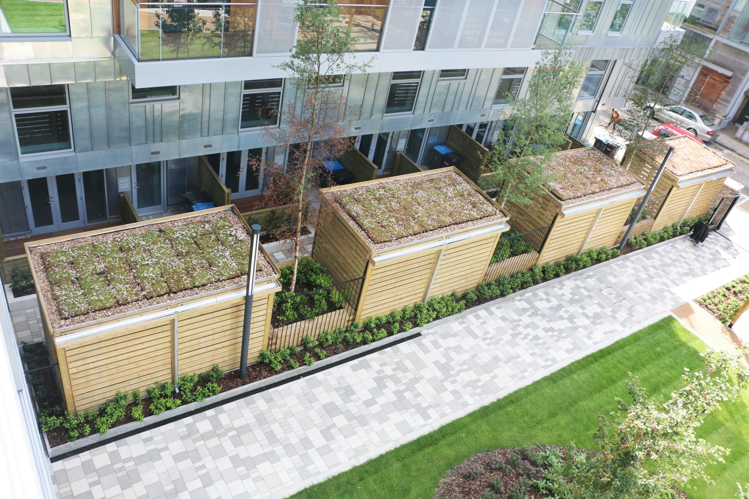 Overlooking x4 wooden huts, with gardens on the roofs. Infant trees have been planted.