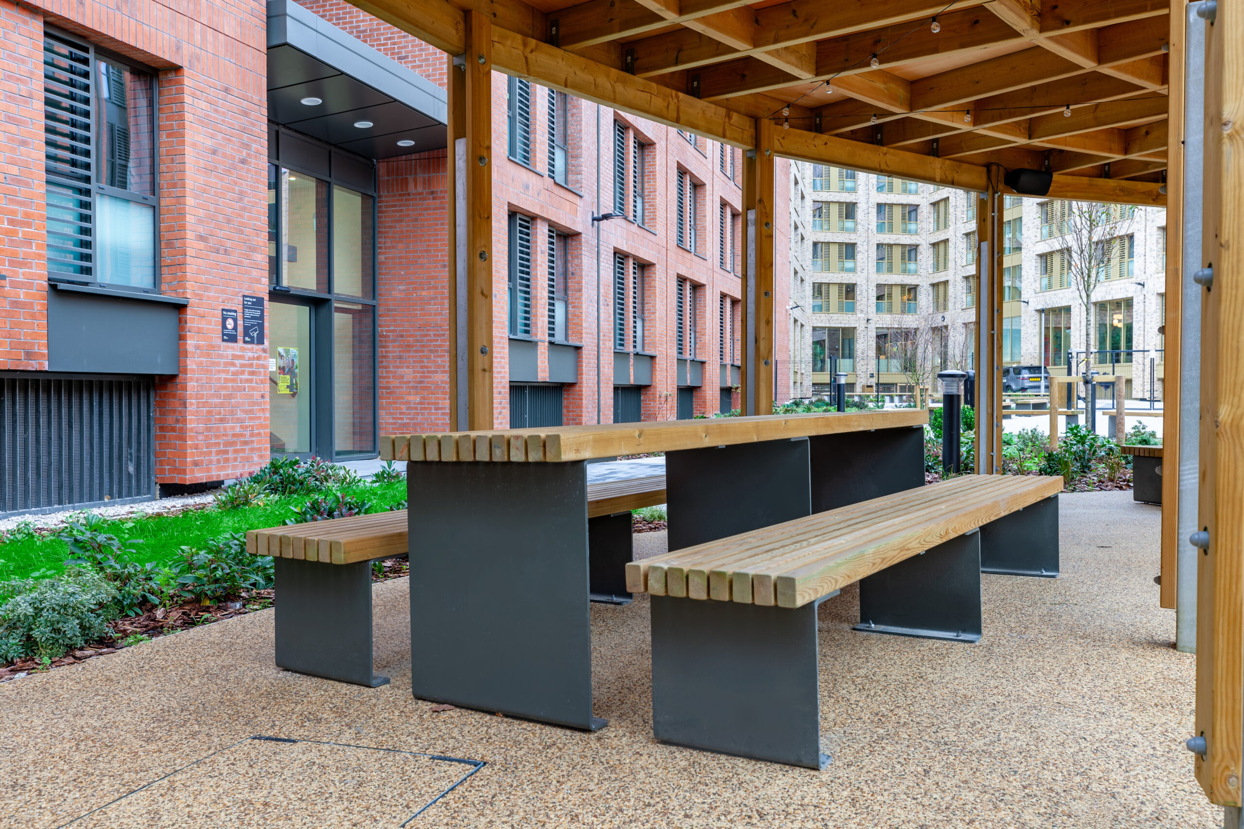 Picnic tables beneath a pergola at Morriss House, Nottingham.